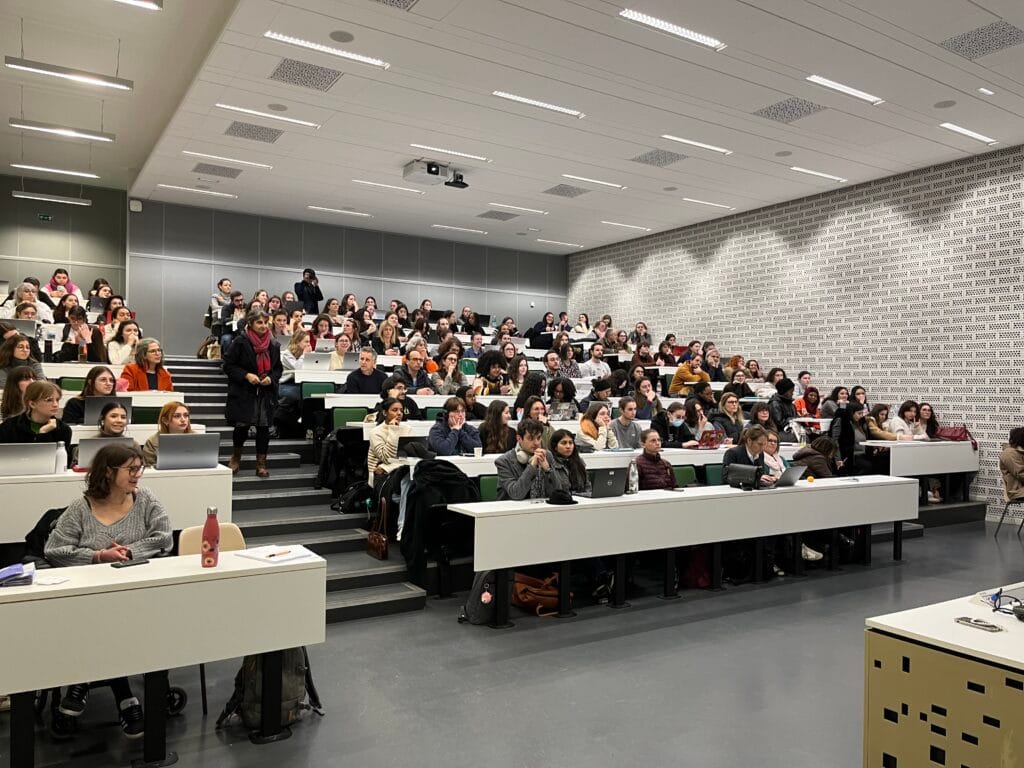 Photo d'étudiants assistant à une conférence dans un amphithéâtre